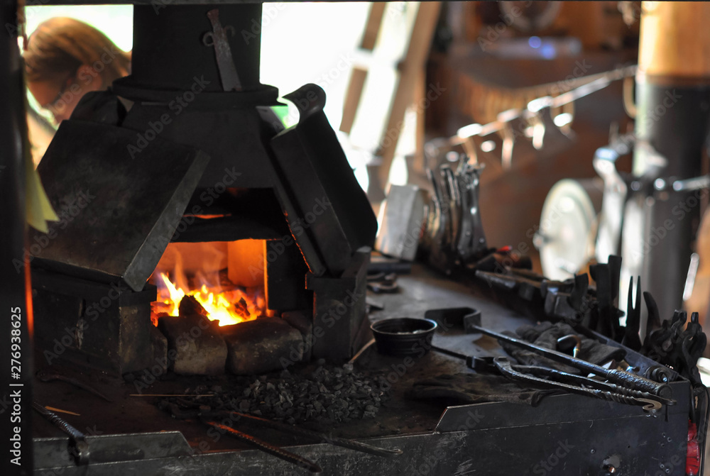 Fire in the furnace, blacksmith tools in an old forge Fire in the furnace, blacksmith tools in an old forge