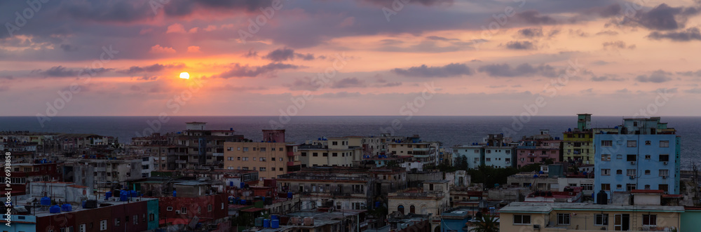 Aerial Panoramic view of the residential neighborhood in the Havana City, Capital of Cuba, during a colorful and cloudy sunset.