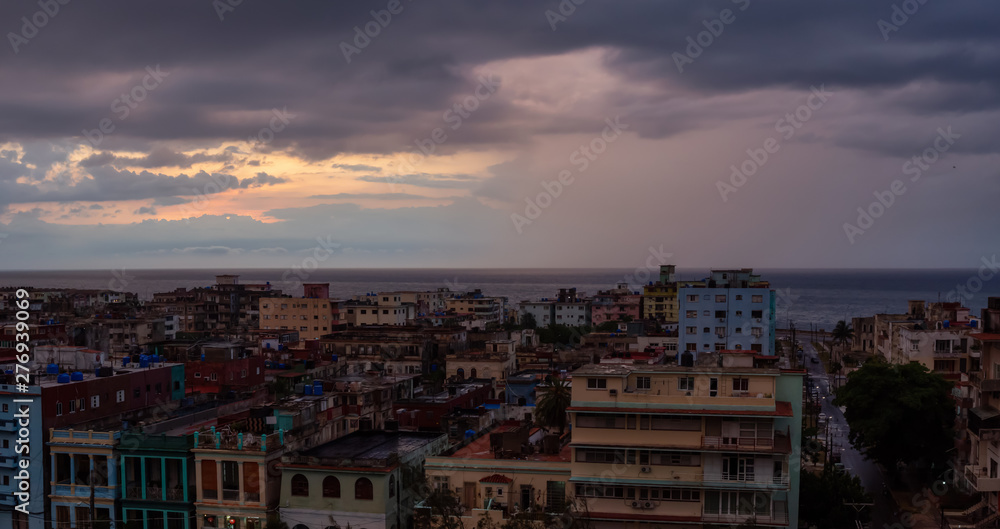 Aerial Panoramic view of the residential neighborhood in the Havana City, Capital of Cuba, during a colorful  and rainy sunset.