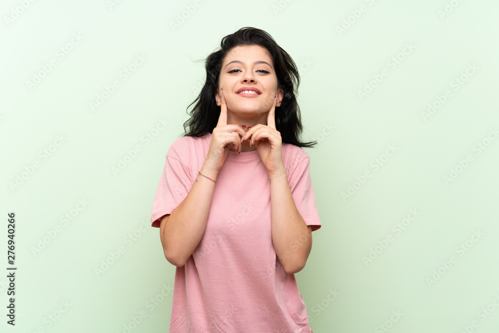 Young woman over isolated green background smiling with a happy and pleasant expression Young woman over isolated green background smiling with a happy and pleasant expression