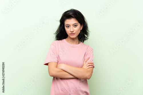 Young woman over isolated green background feeling upset