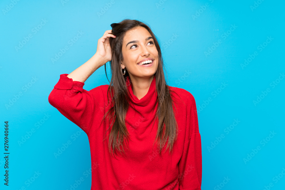 Young woman with red sweater over isolated blue background laughing Young woman with red sweater over isolated blue background laughing