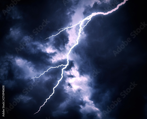 Lightning strike on a cloudy dark rainy sky.