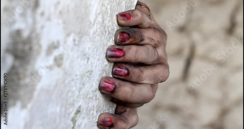 In and out of focus of dirty hands on a rock wall.