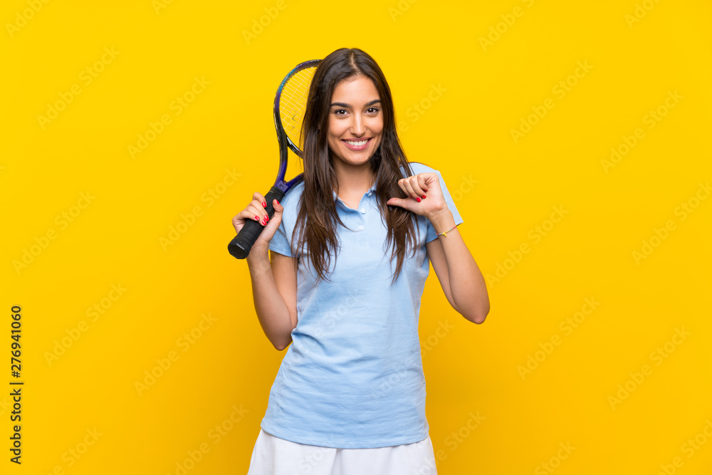 Young tennis player woman over isolated yellow wall proud and self-satisfied Young tennis player woman over isolated yellow wall proud and self-satisfied