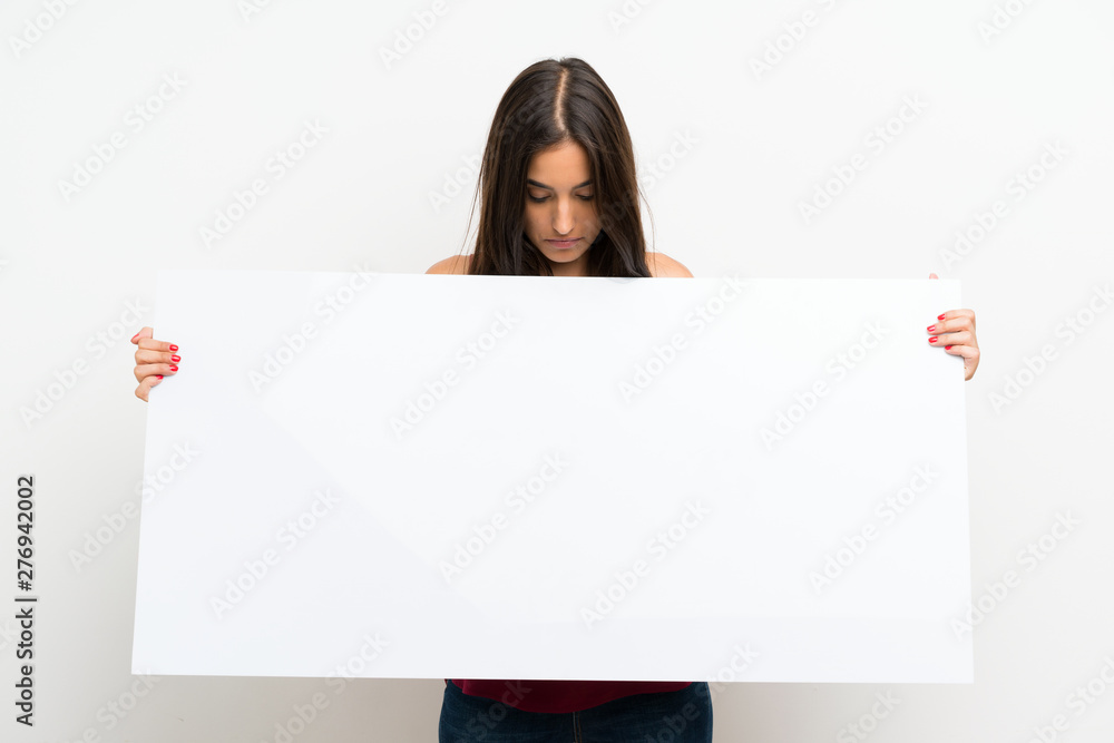 Young woman over isolated white background holding an empty white placard for insert a concept Young woman over isolated white background holding an empty white placard for insert a concept
