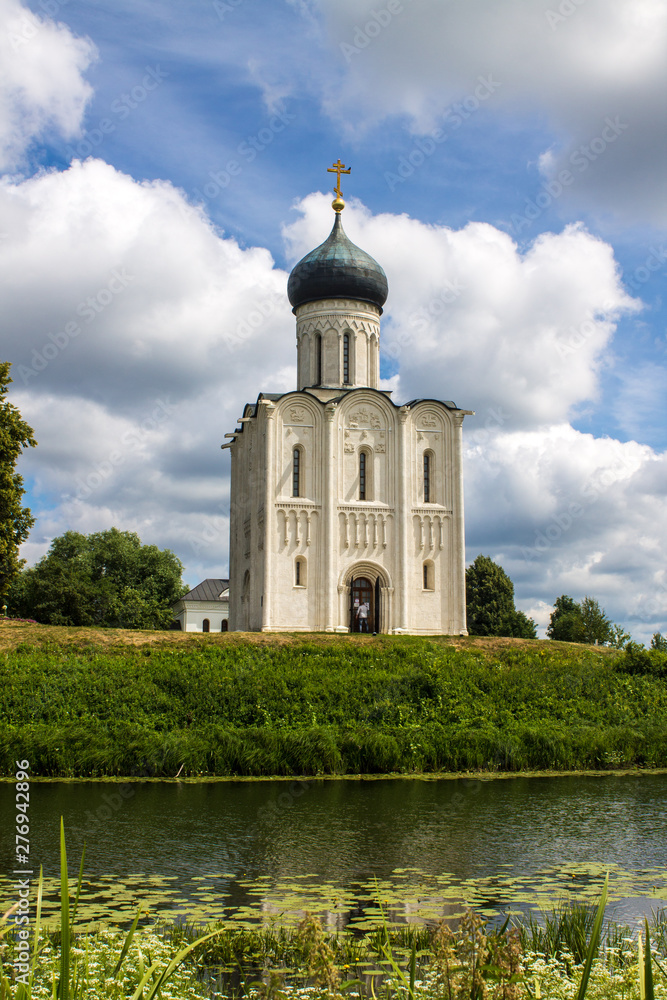 White stone Church of the Intercession on the Nerl with reflection in the water summer day Russia White stone Church of the Intercession on the Nerl with reflection in the water summer day Russia