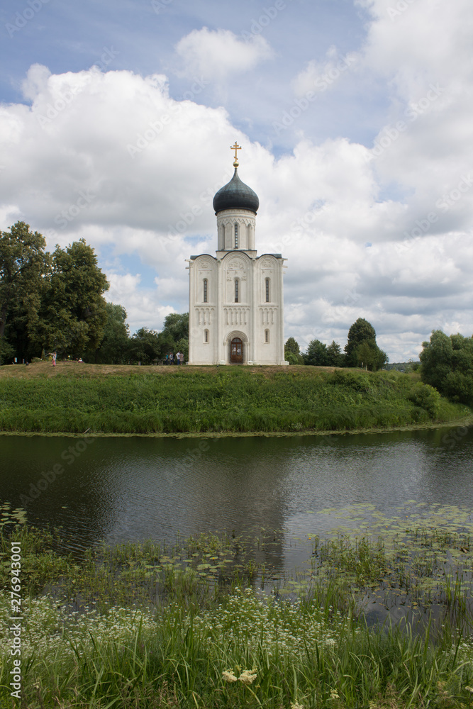 White stone Church of the Intercession on the Nerl with reflection in the water summer day Russia