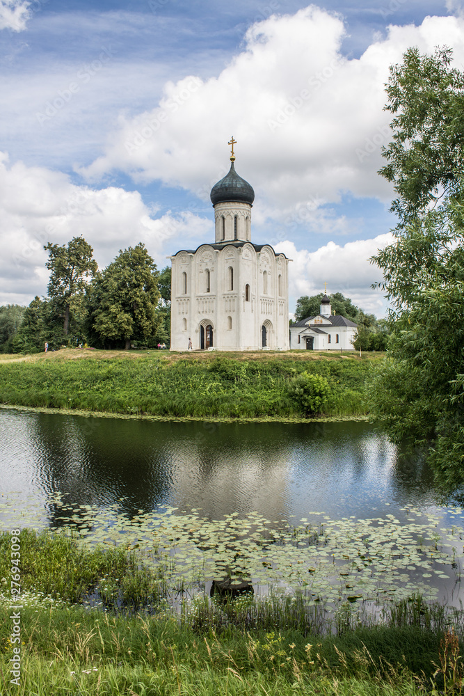 White stone Church of the Intercession on the Nerl with reflection in the water summer day Russia White stone Church of the Intercession on the Nerl with reflection in the water summer day Russia