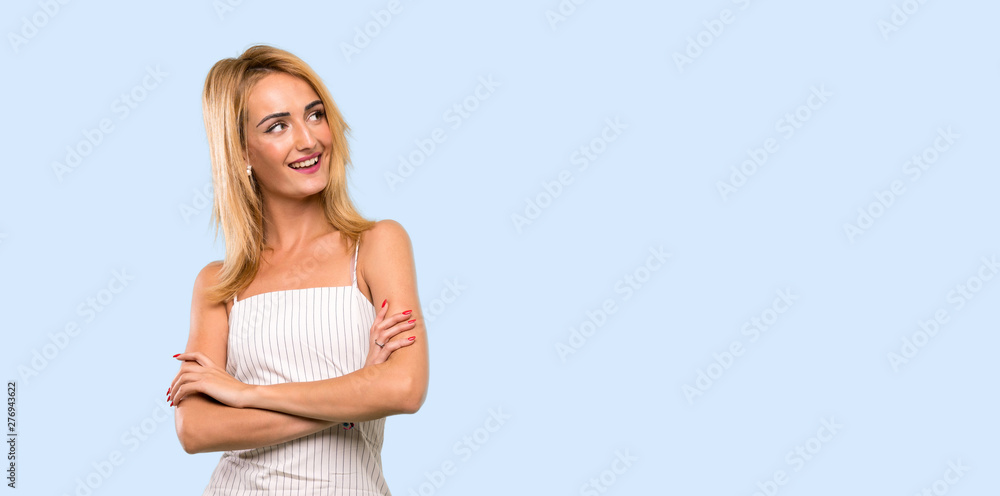 Young blonde woman happy and smiling over isolated blue background Young blonde woman happy and smiling over isolated blue background