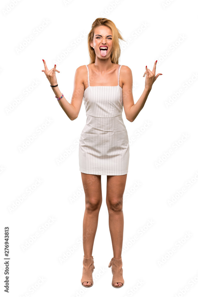 A full-length shot of a Young blonde woman making rock gesture over isolated white background A full-length shot of a Young blonde woman making rock gesture over isolated white background