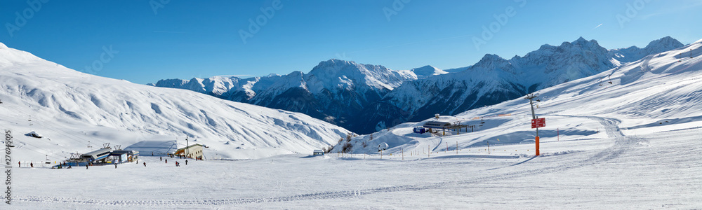 Snowy mountains panoramic view from the ski piste near Scuol resort in Switzerland.