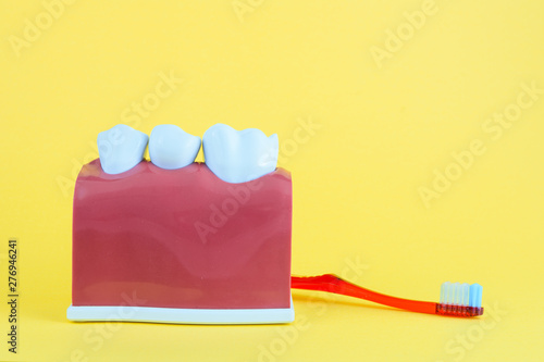 False mouth on yellow background with toothbrush