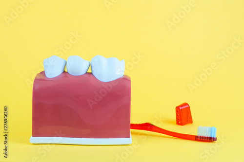 False mouth on yellow background with toothbrush