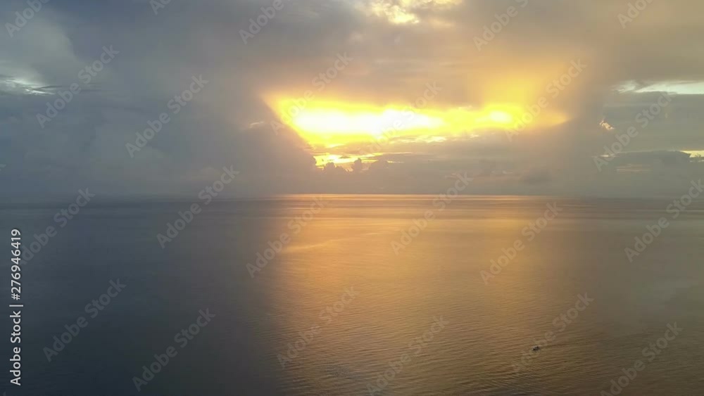 Sunrise on the tropical sea. Aero shooting from the drone,The coast with palm trees, the Sun to shine through clouds, Fishing boats in the sea Sunrise on the tropical sea. Aero shooting from the drone,The coast with palm trees, the Sun to shine through clouds, Fishing boats in the sea