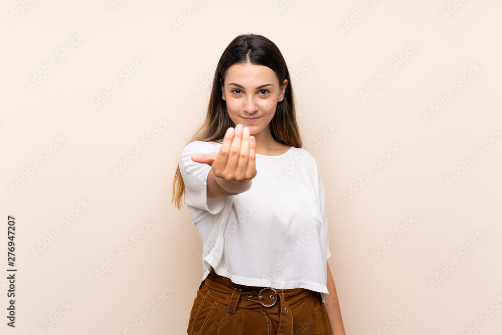 Young brunette woman over isolated background inviting to come with hand. Happy that you came Young brunette woman over isolated background inviting to come with hand. Happy that you came