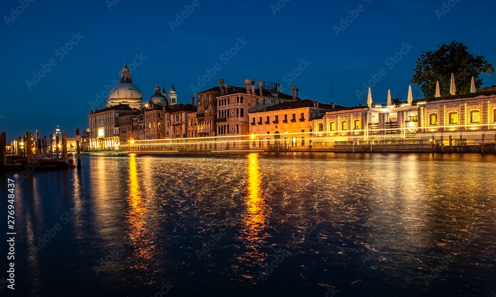 View of Grand Canal and Basilica della Salute at night with boat night trails