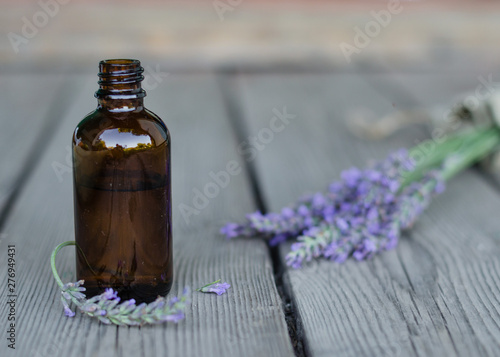 Fototapeta Naklejka Na Ścianę i Meble -  Lavender essential oil. Dark bottle of essential oil with fresh lavender twigs.  natural face and body beauty care concept.