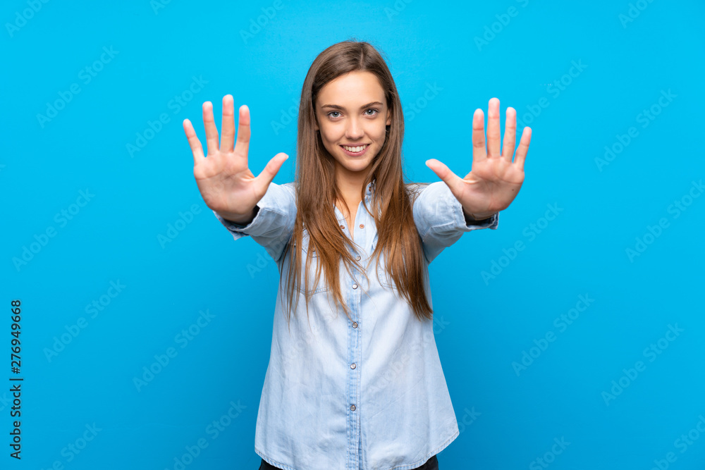 Young woman over isolated blue background making stop gesture and disappointed Young woman over isolated blue background making stop gesture and disappointed