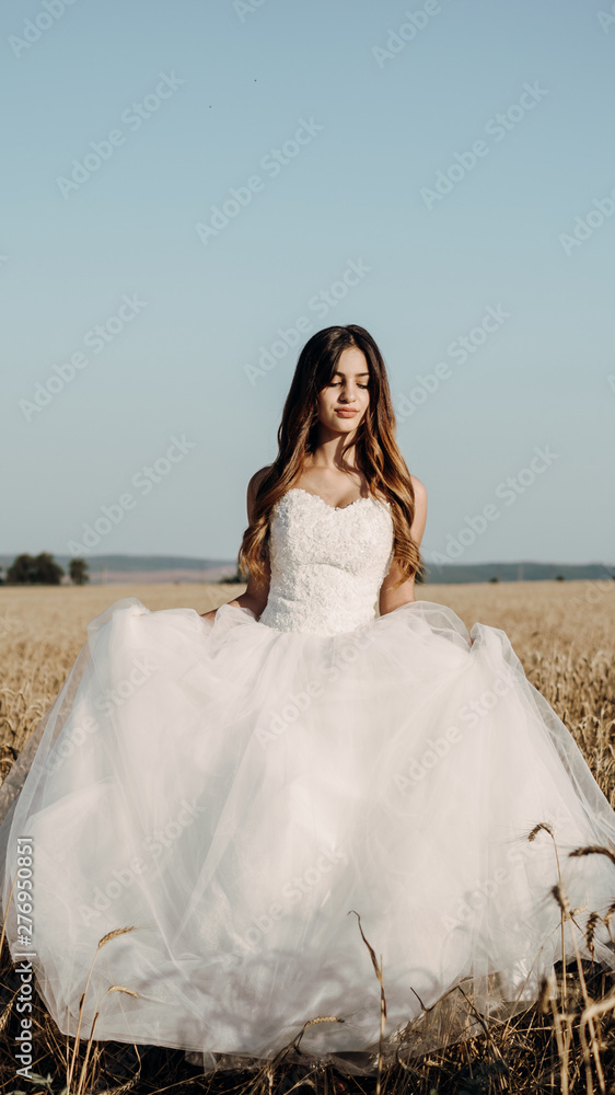 Beautiful bride in wheat field on sunset