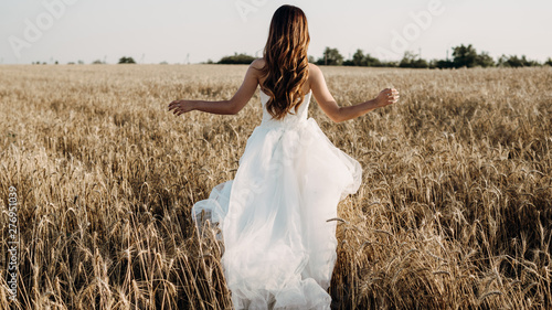 Fotografie Beautiful bride in wheat field on sunset