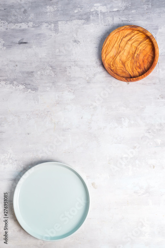 Rustic tableware  wooden bowls and ceramic plates with a copy space on stone background