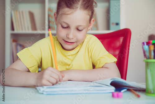 Portrait of pretty school girl are studying at classroom at the table