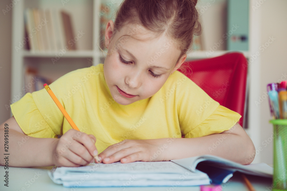 Portrait of pretty school girl are studying at classroom at the table Portrait of pretty school girl are studying at classroom at the table