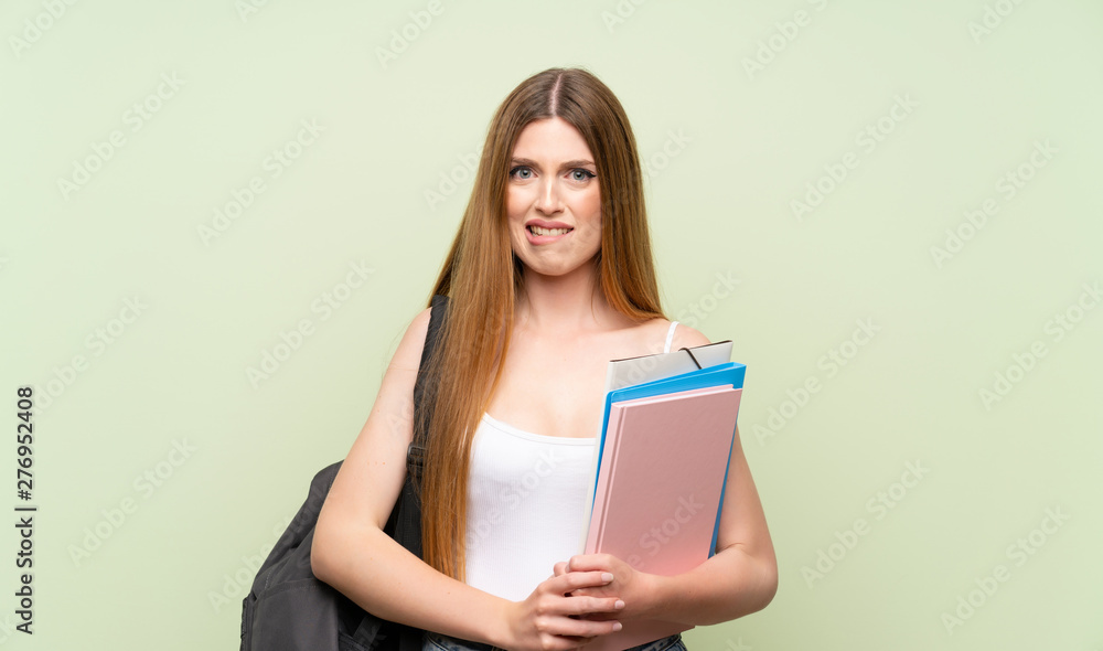 Young student woman over isolated green background having doubts and with confuse face expression Young student woman over isolated green background having doubts and with confuse face expression