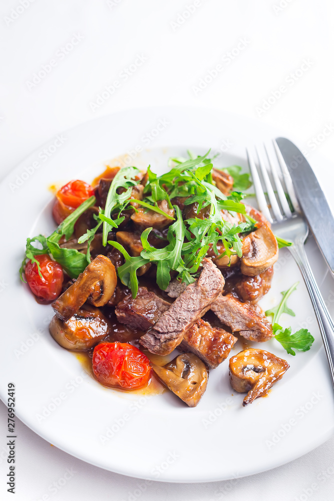 Juicy steak medium rare beef with arugula and grilled vegetables. Top view Juicy steak medium rare beef with arugula and grilled vegetables. Top view