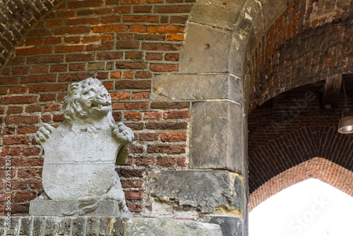 sculpture of lion against brick wall, in gate called Broerderpoort. Kampen, The Netherlands_-4 photo