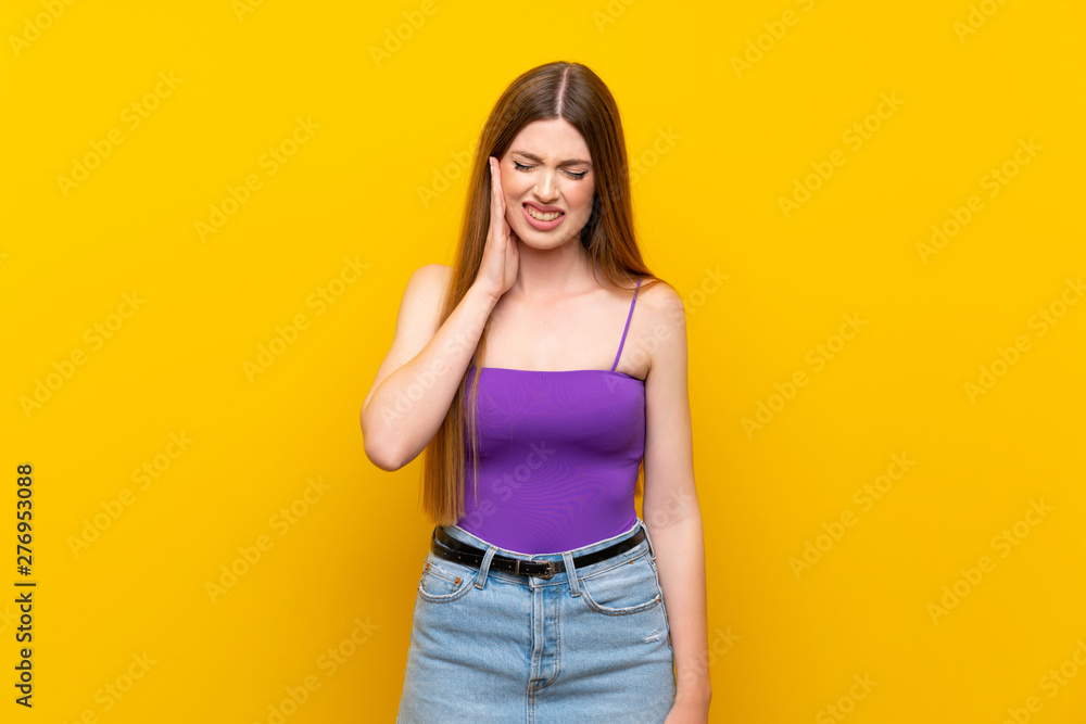 Young woman over isolated yellow background with toothache Young woman over isolated yellow background with toothache