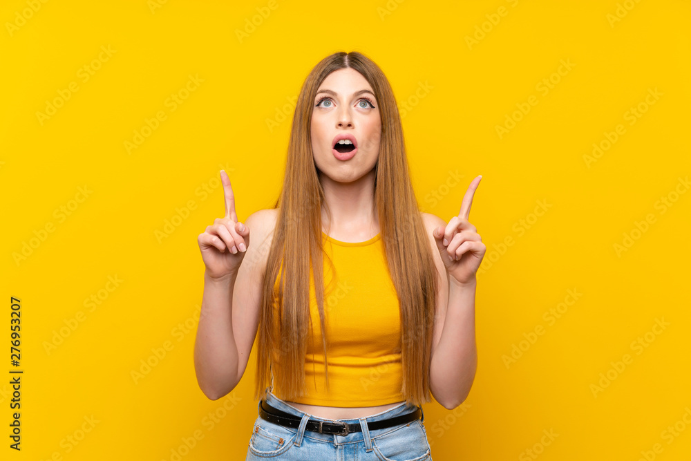 Young woman over isolated yellow background pointing with the index finger a great idea Young woman over isolated yellow background pointing with the index finger a great idea