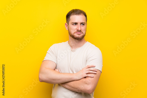 Handsome man over yellow background thinking an idea