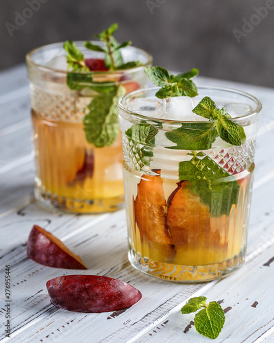 Two plum cocktails with mint leaves