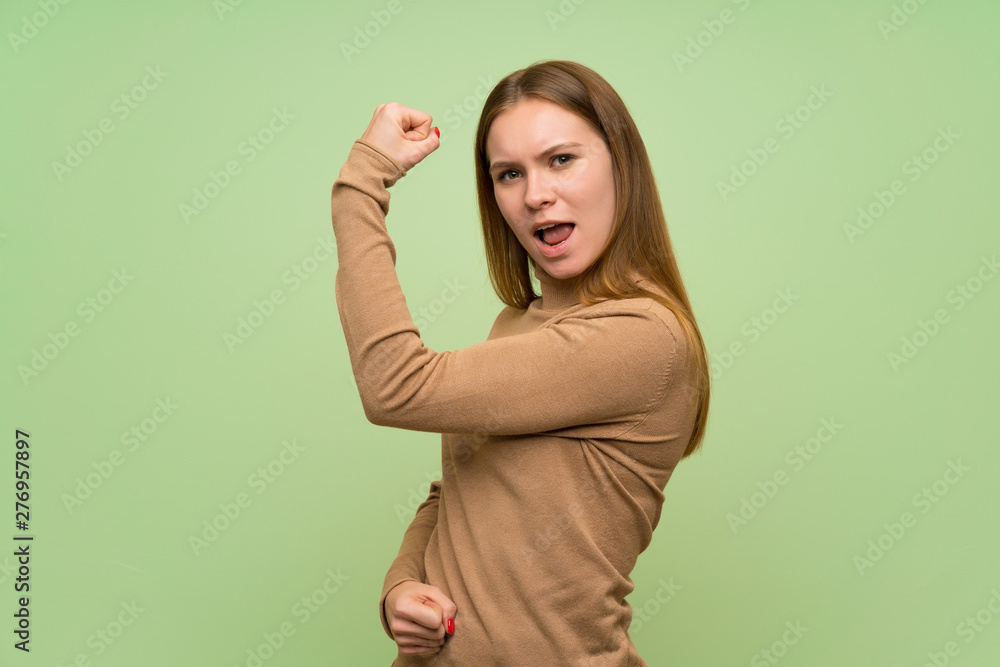 Young woman with turtleneck sweater doing strong gesture Young woman with turtleneck sweater doing strong gesture