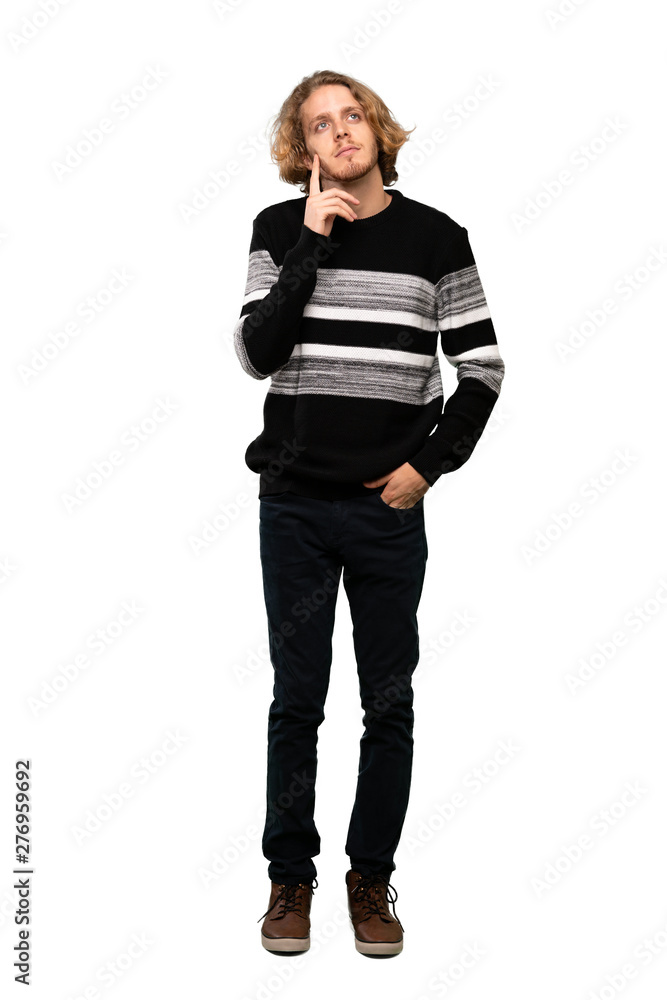 Full-length shot of Blonde man thinking an idea while looking up over isolated white background Full-length shot of Blonde man thinking an idea while looking up over isolated white background