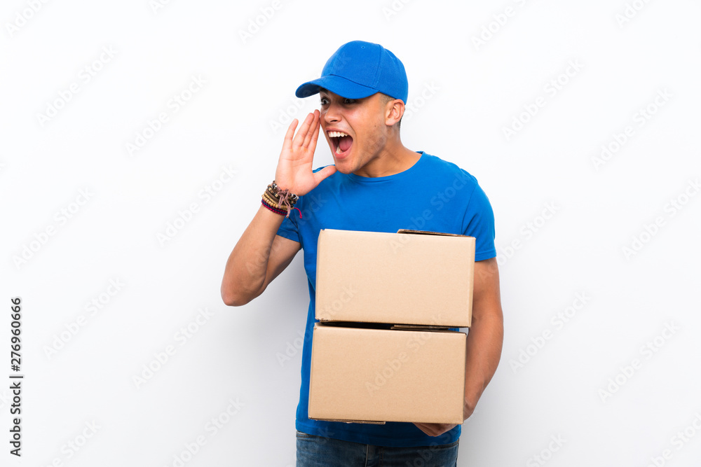 Delivery man over isolated white wall shouting with mouth wide open Delivery man over isolated white wall shouting with mouth wide open