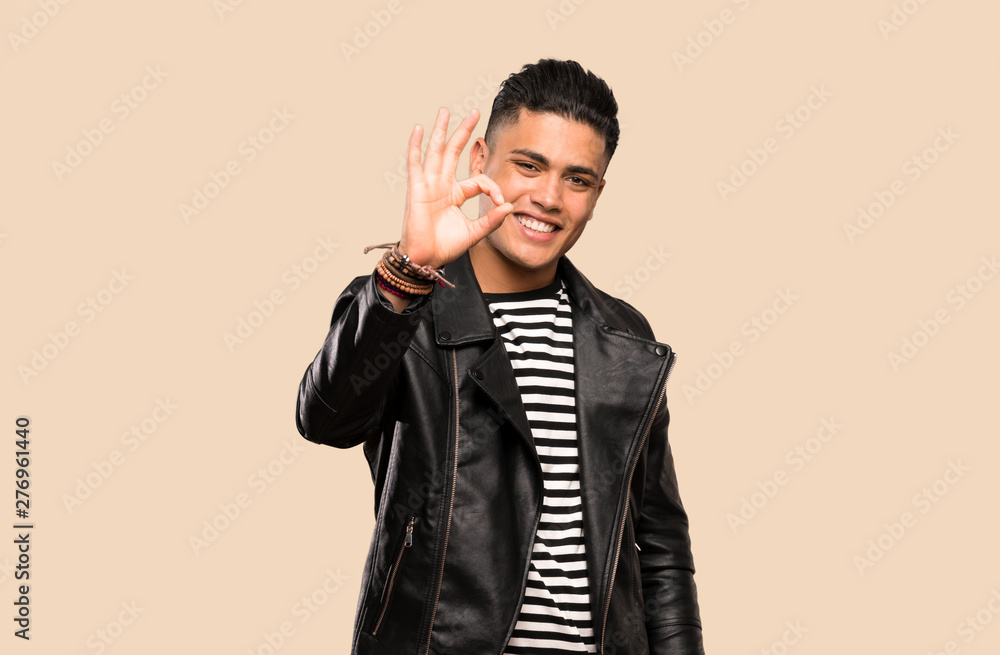 Young man showing ok sign with fingers over isolated background Young man showing ok sign with fingers over isolated background