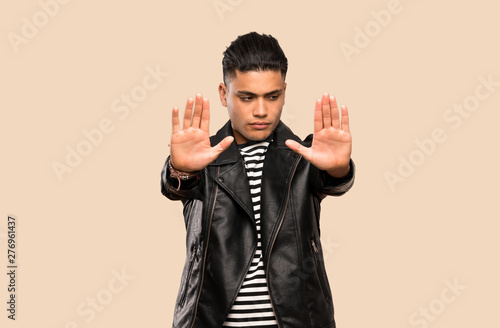 Young man making stop gesture and disappointed over isolated background © luismolinero
