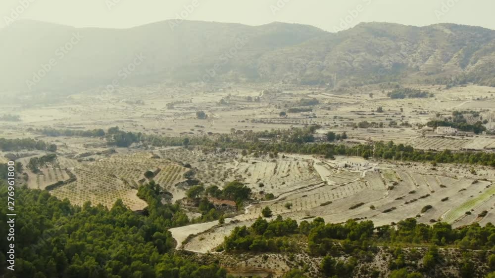 Aerial forward drone shot, vast agricultural plantation reveals behind green hills, Spain Aerial forward drone shot, vast agricultural plantation reveals behind green hills, Spain