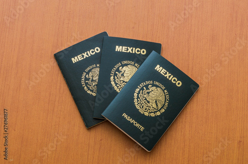 Obraz na plátne Tres pasaportes mexicanos apilados sobre mesa de madera