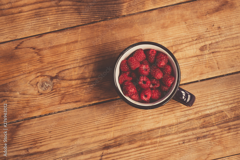 Fresh raspberries background closeup photo. Red raspberries in metal cup on wooden table. Vintage style Fresh raspberries background closeup photo. Red raspberries in metal cup on wooden table. Vintage style