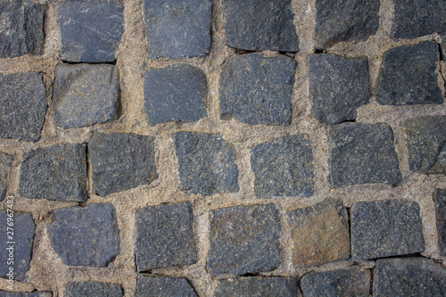 old stone pavement of blue stones of various shapes and sizes with light cement. rough surface texture