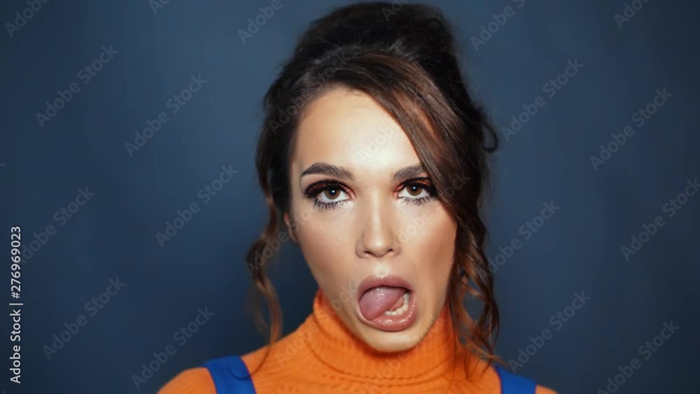 Young woman with beautiful appearance showing tongue. Girl showing grimaces Young woman with beautiful appearance showing tongue. Girl showing grimaces