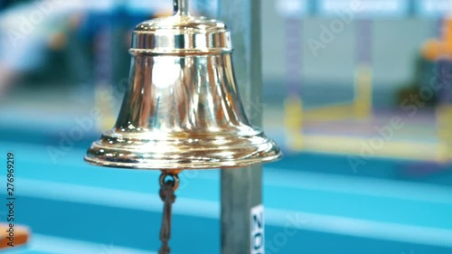 Referee ringing bell at finish of competition. Sports handbell closeup photo