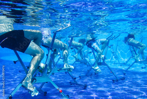 Fitness class. Water aerobics classes on exercise bikes in the pool