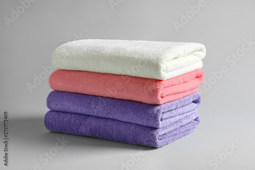 Stack of fresh fluffy towels on grey background