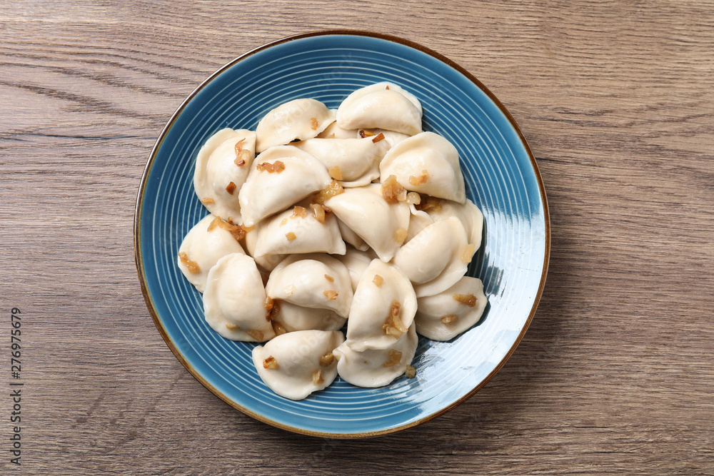 Plate of tasty cooked dumplings on wooden table, top view Plate of tasty cooked dumplings on wooden table, top view