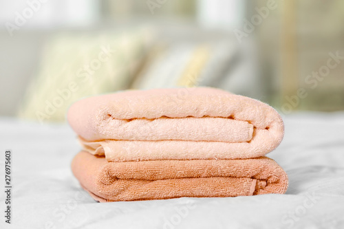 Stack of clean terry towels on bed, closeup